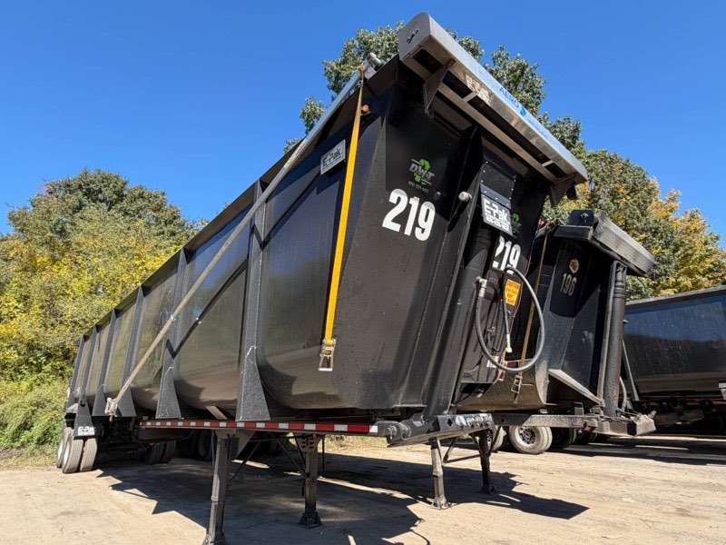 Trailer 219, a black dump trailer, parked in the yard